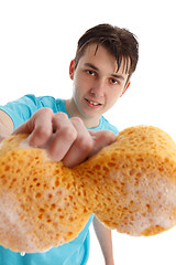 Image showing Teenager with outstretched hand holding a soapy sponge