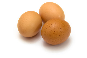Image showing Three eggs lying down on a white linen background