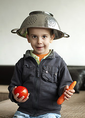 Image showing Boy with tomato and carrot in hand