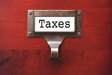 Image showing Lustrous Wooden Cabinet with Taxes File Label