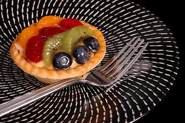 Image showing Fruit tart on black and white plate