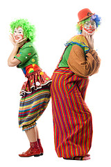 Image showing Two smiling clowns are back to back