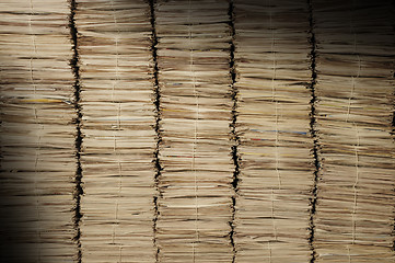 Image showing Piles of newspapers to be recycled lit diagonally