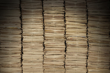 Image showing Piles of newspapers to be recycled lit from above