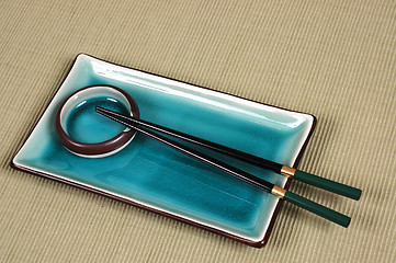 Image showing Plate, dipping bowl and chop sticks on green mat