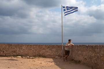 Image showing  youth on stone castle under the greece flag