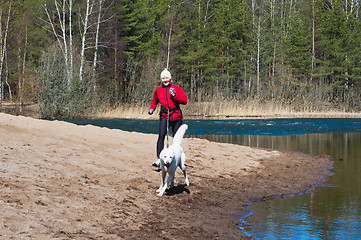 Image showing Running the sports woman with a dog