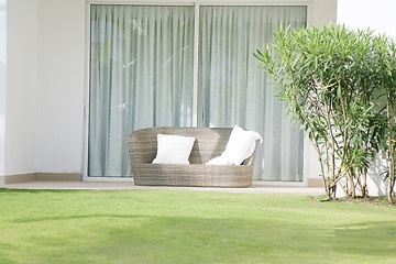 Image showing A large chair cushion in front of a large open window 