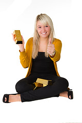 Image showing Young girl with goldbar giving thumps up