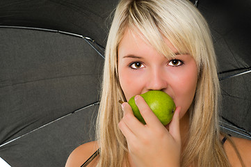 Image showing Young girl eating a pear