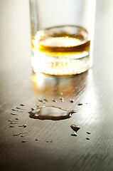 Image showing Glass with whiskey and drops on the table