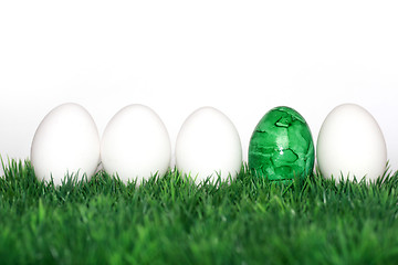 Image showing A green egg between the white 