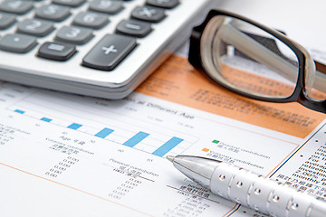 Image showing Stock chart with calculator,pen and eyeglasses 