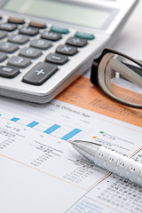 Image showing Stock chart with calculator,pen and eyeglasses 