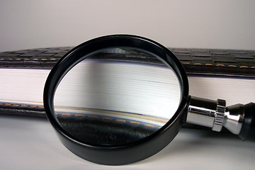 Image showing magnifying glass and leather notebook