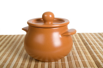 Image showing Clay pot on the striped mat