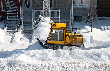 Image showing Yellow snowplough removing snow in the city