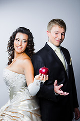 Image showing bride offering a red apple to doubting groom