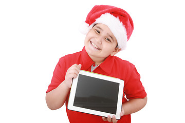 Image showing Adorable child with Santa hat offering a tablet isolated on whit