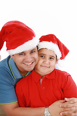 Image showing Happy father and son with Christmas hats look to the camera