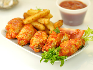 Image showing hot chicken wings with fried potatoes 