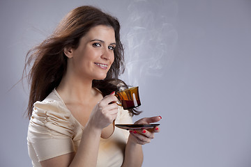 Image showing Woman drinking a hot drink