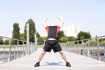 Image showing Athlete warming and stretching