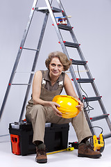 Image showing Senior woman sitting in a toolbox