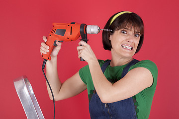 Image showing Stressed woman holding a electric drill