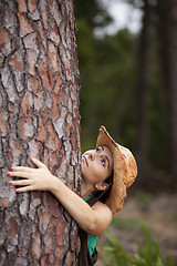 Image showing Young woman embracing a tree