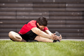 Image showing Athlete warming and stretching