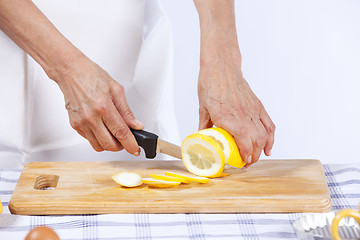 Image showing Hands cutting lemon