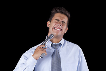 Image showing Businessman aiming a handgun at his head