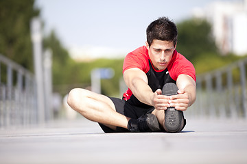 Image showing Athlete warming and stretching