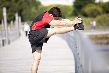 Image showing Athlete warming and stretching