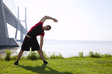 Image showing Athlete warming and stretching