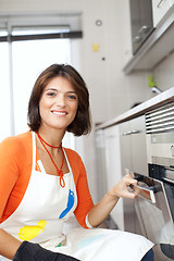 Image showing Woman opening the kitchen oven