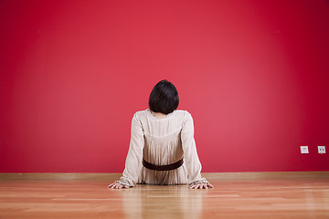 Image showing Woman looking to a red wall