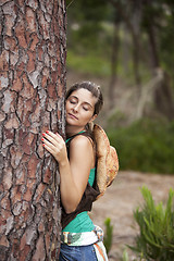 Image showing Young woman embracing a tree