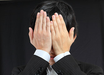 Image showing businessman covering his face by hands 