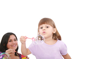 Image showing Portrait of funny lovely little girl blowing soap bubbles with h