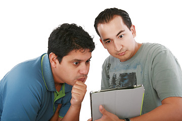 Image showing Two friends looking surprised at tablet computer against a white