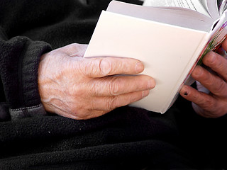 Image showing Hands of an old man holding a book