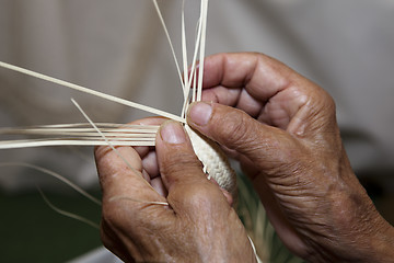 Image showing Old woman's hands and wicker straw hat