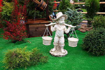 Image showing toy boy carries baskets through field