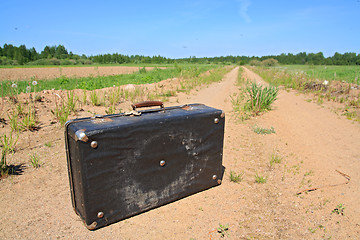 Image showing old valise on rural road 