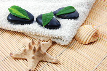 Image showing foldet white bath towel and zen stones