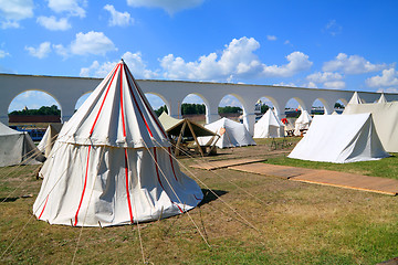 Image showing white tents near ancient wall