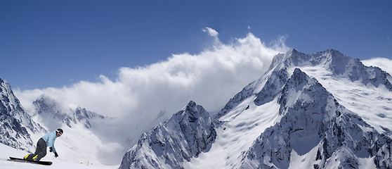 Image showing Panorama snow mountains with snowboarder