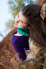 Image showing Portrait of a young woman lying on log 